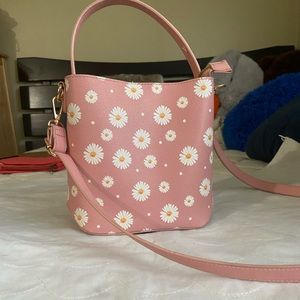 Pink bag with white daisies crossbody strap